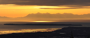 silhouette of seashore beside body of water during golden hour, alaska