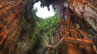 concrete building under green and brown rock cave