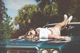 woman lying down on teal car HD wallpaper