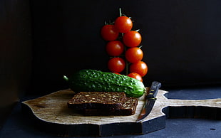 red tomatoes; green cucumber; and slice of cake on cutting board HD wallpaper