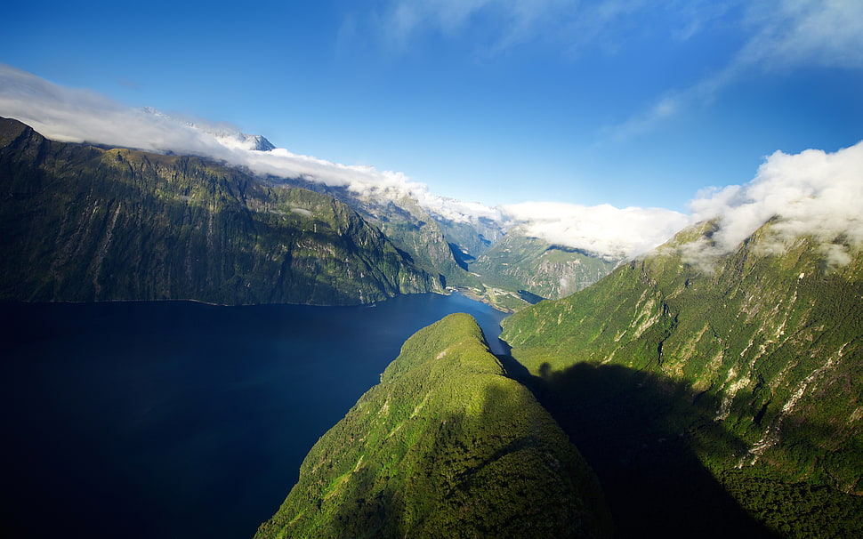 river between mountains under blue sky during daytime HD wallpaper