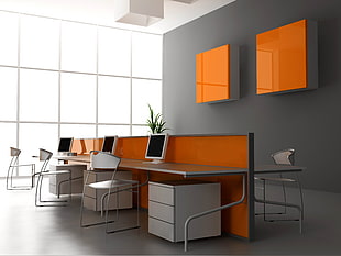 orange and white wooden desk with white LED monitors