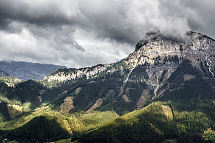 greenfield near rock mountain hills under cloudy sky during daytime HD wallpaper