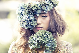 selecive focus photography of a woman with bunch of flowers in her head