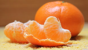 shallow focus photo of orange slices and a whole orange HD wallpaper