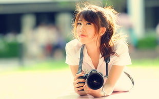 woman in white collared shirt using DSLR camera in selective focus photography