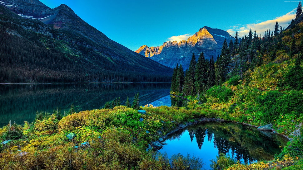body of water between mountain during daytime HD wallpaper