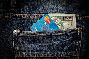 magstripe card and banknote in blue denim bottoms back pocket