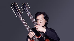 man in black long-sleeved shirt holding guitar