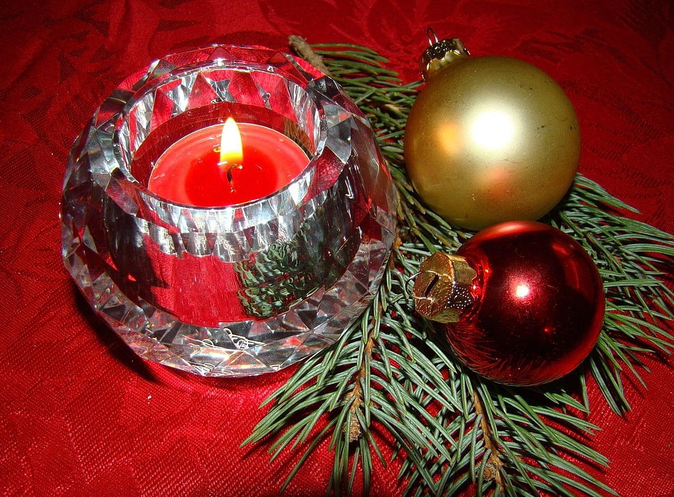 red lighted votive candle with two brown and red christmas baubles HD wallpaper