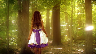 girl in white and purple dress and trees