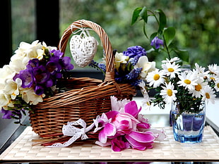 white and purple orchid inside basket on table