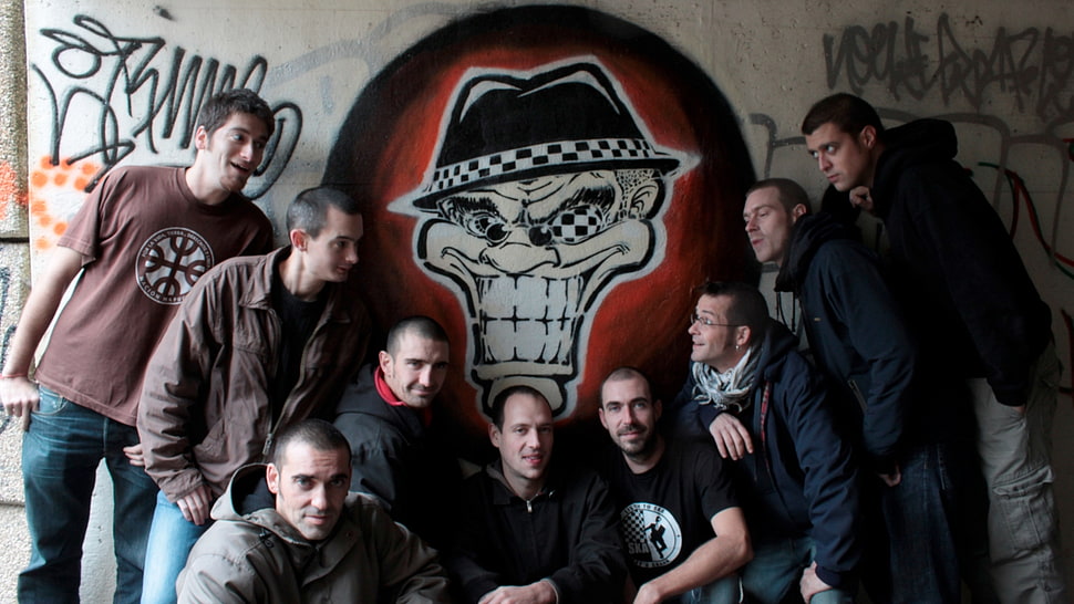 photo of nine man beside beige skull painted wall HD wallpaper