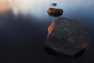 three gray stone debris on body of water