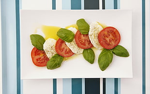 sliced tomatoes above rectangular white ceramic plate