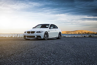white BMW sedan on gray asphalt flooring