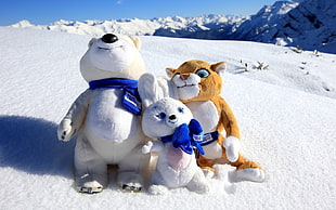 white rabbit between white bear and brown tiger plush toy on snow field land during daytime HD wallpaper