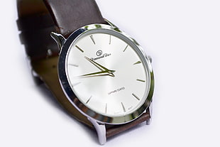 round silver-colored analog watch with brown leather bands