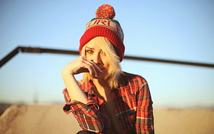 woman in red bobble hat and plaid shirt