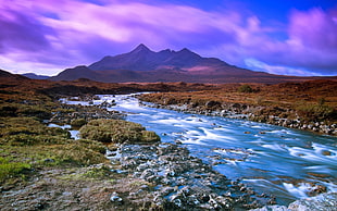 landscape photography of lake with green grass field and mountain in the background
