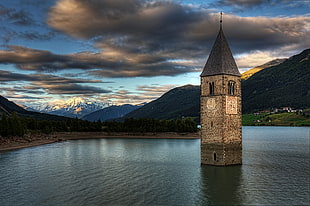 concrete tower in the middle of body of water