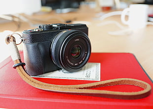 photo of black DSLR camera on red book cover