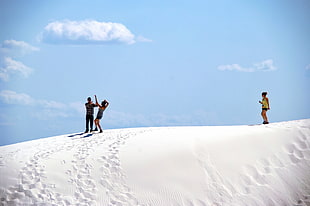 three person on top of white snow during daylight HD wallpaper