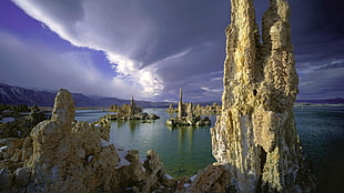 white rock formations near ocean water under cloudy sky during daytime, landscape