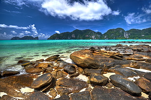 rocks on seashore over looking islands HD wallpaper