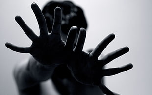 grayscale photo of person reaching his hand