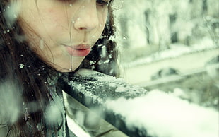 depth of field photography of woman blowing snow