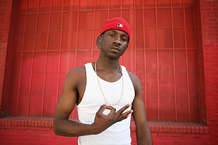 man wearing red tank top and red fitted cap
