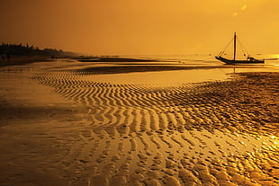 beach shore with sail boat during golden time