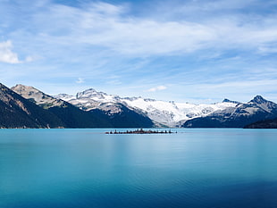 island in the surrounded by water and mountains covered with snow