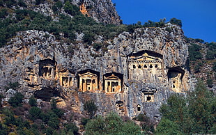 brown concrete buildings beside rock formations