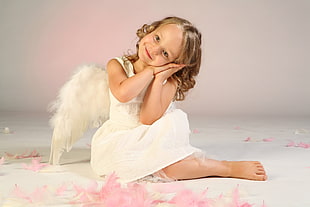girl wearing white sleeveless dress with angel wings