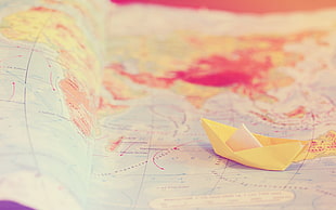 yellow paper boat on map