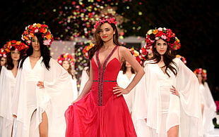 woman in red dress in front of women in white dress