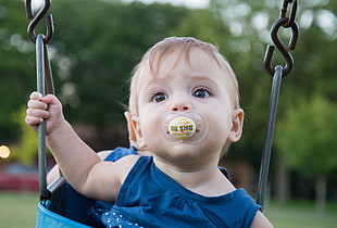 baby with pacifier on swing
