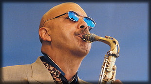 man plays brass saxophone