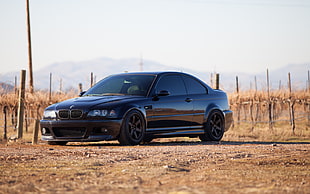 black BMW E46 parked on dirt road during daytime