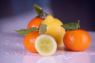 lemon and orange fruits on white surface