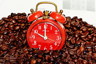 red alarm table clock on coffee beans