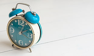 blue and brass-colored 2-bell alarm clock