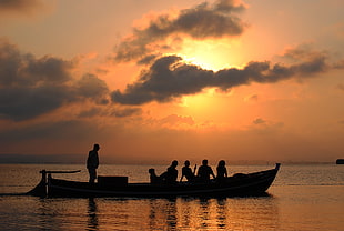 silhouette of people riding on boat
