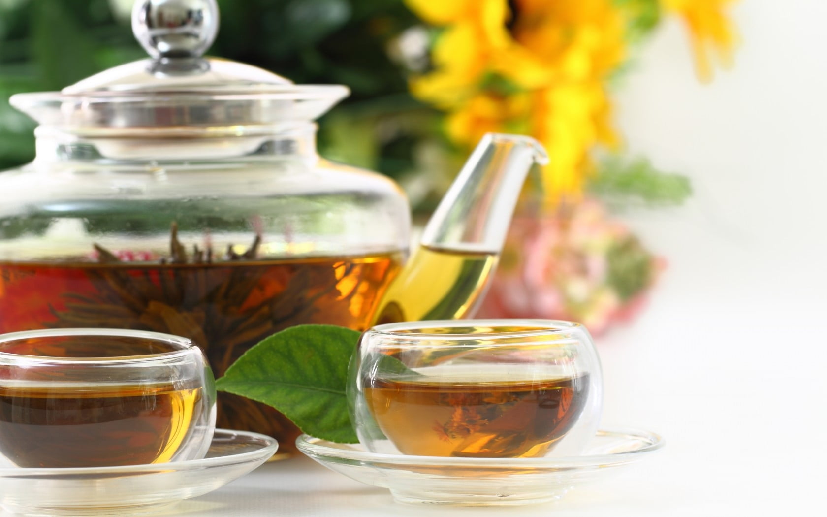 clear glass teapot with tea cup with tea