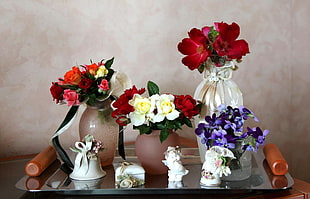 white ceramic vases with assorted flower arrangements