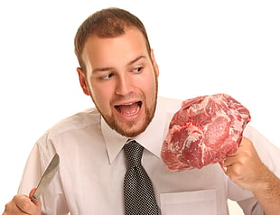 man in white dress shirt holding raw meat