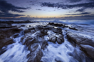 time lapse photography of rocks on sea during sunrise