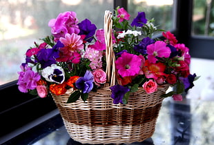 selective focus photography of pink and purple petaled flowers in brown wicker bkaset